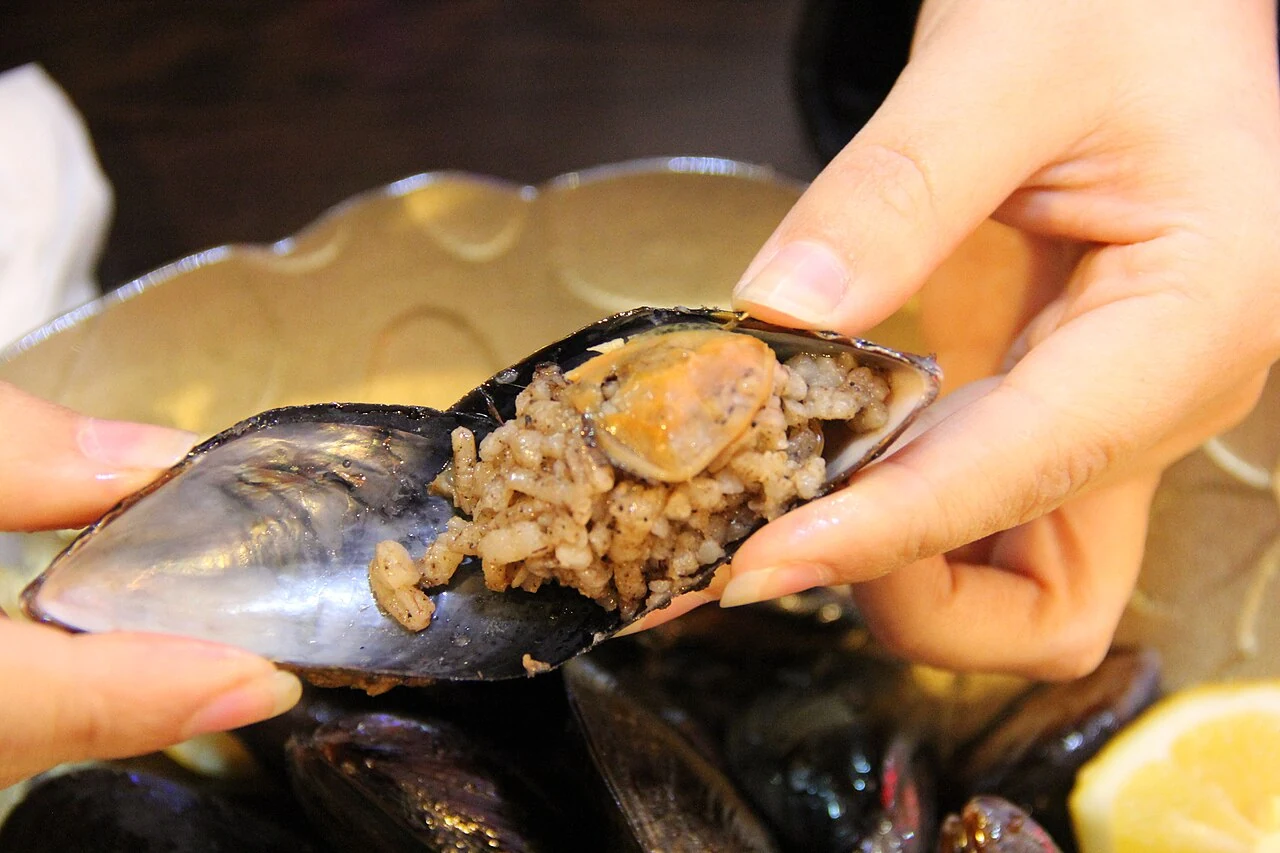 A stuffed mussel showing its seasoned rice filling.