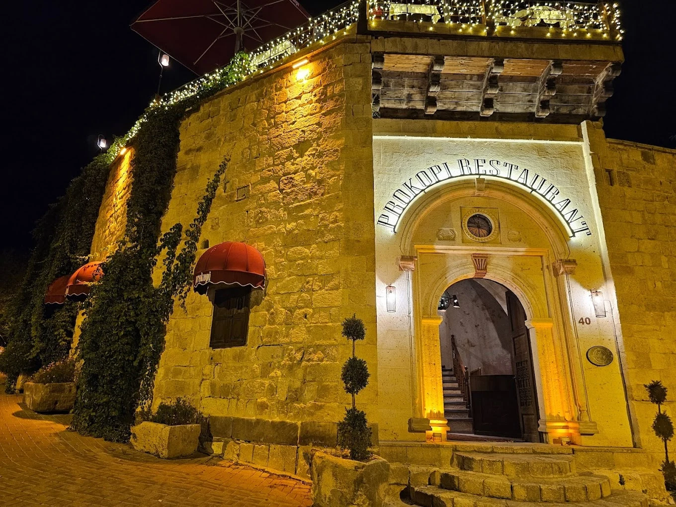 Stone facade and illuminated entrance of Prokopi Restaurant in Ürgüp