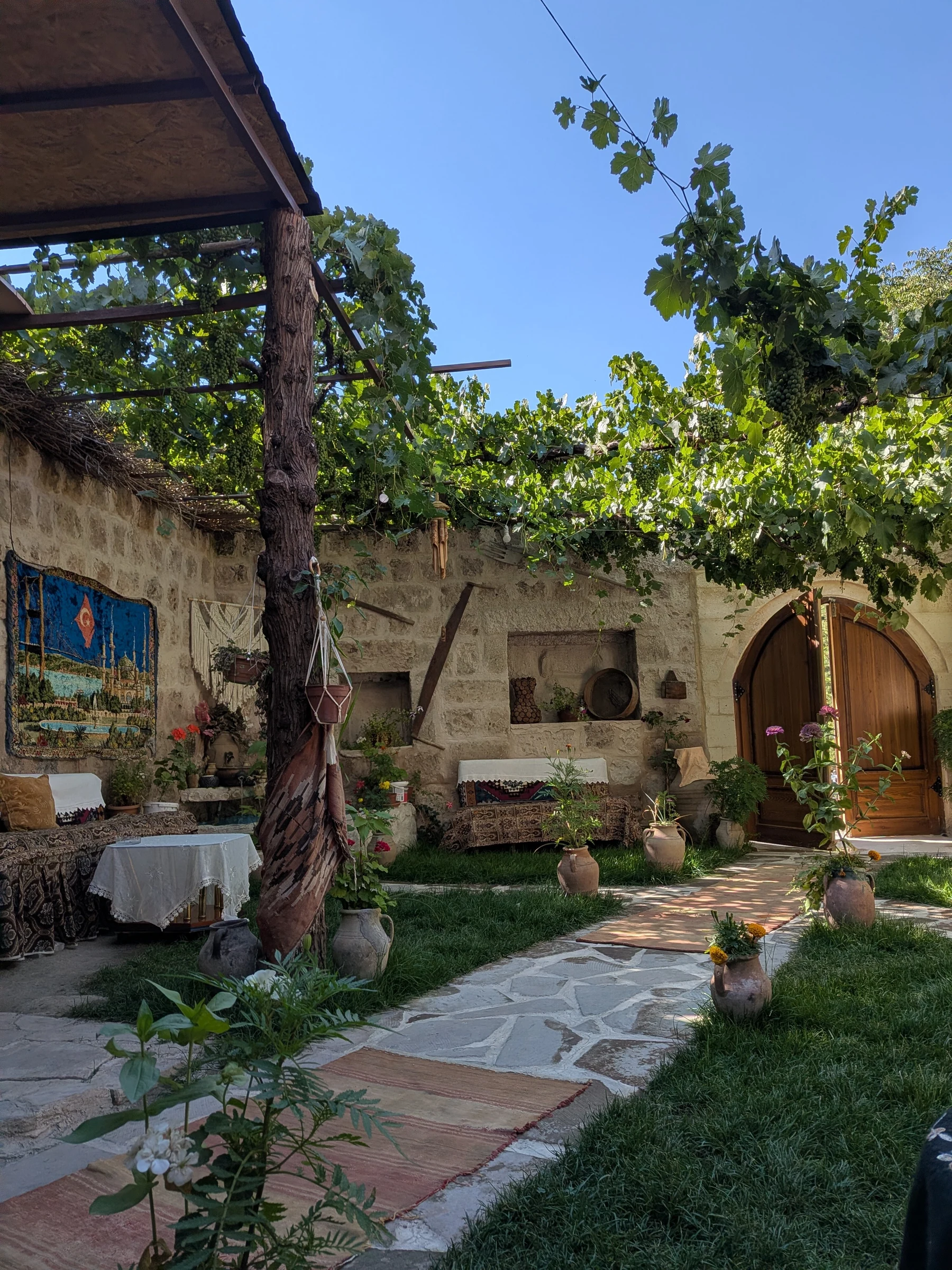 Garden and stone exterior at Şirhanem Cave Restaurant in Ayvalı