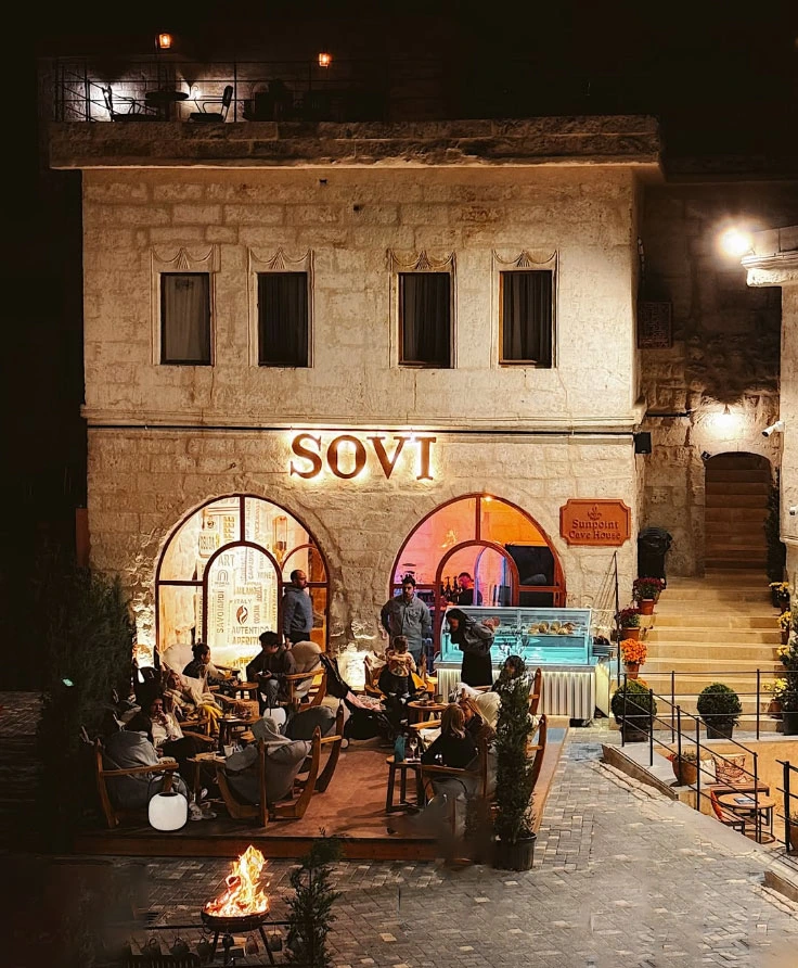 Sovi cafe stone facade and outdoor seating after dusk